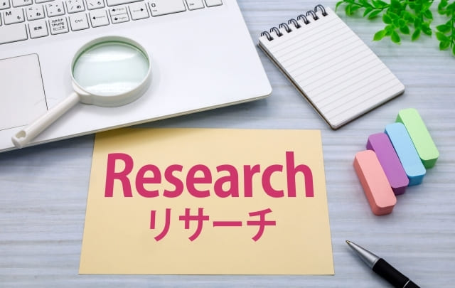 机の上にパソコンとメモ帳が置かれている画像