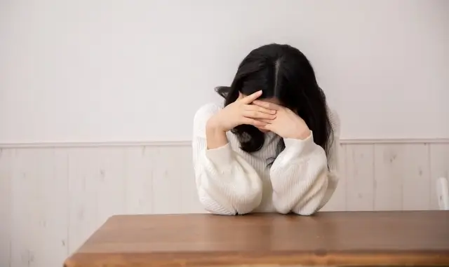 下を向いて悩んでいる女性
