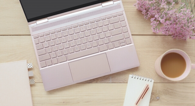 デスクの上にあるパソコンとメモ帳