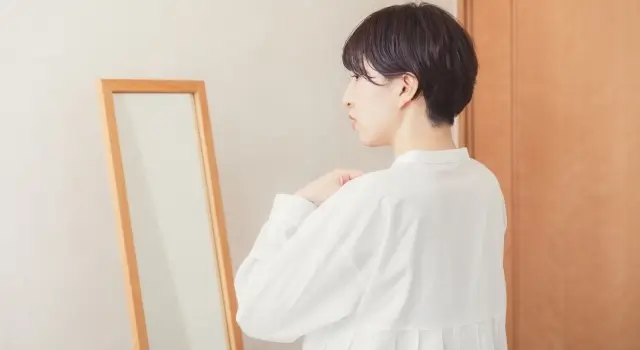鏡で着替えている女性