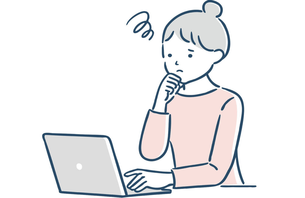 パソコンの前で困っている女性